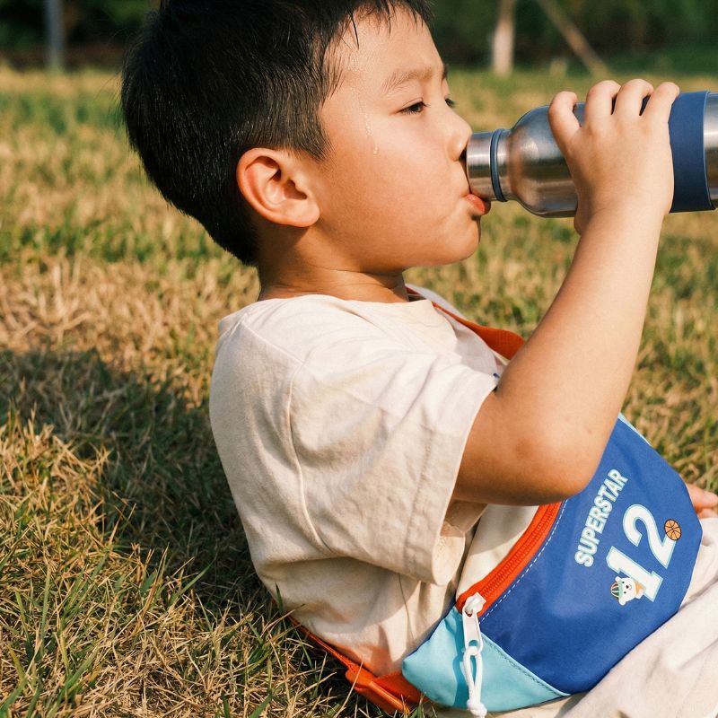 garçon boit a la gourde et porte un banane enfant garçon
