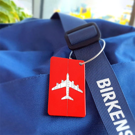 Étiquette à bagage avion rouge sur sac bleu