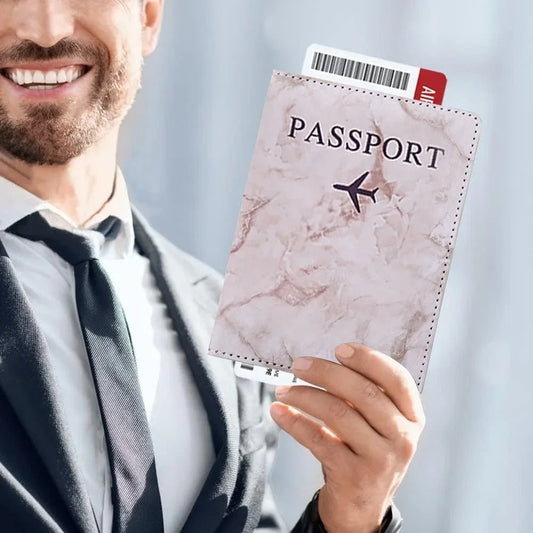 homme portant un porte passeport couleur marbre avec son billet d'avion a l'intérieur