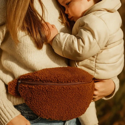 maman avec banane en fourrure moumoute brune qui porte son bébé