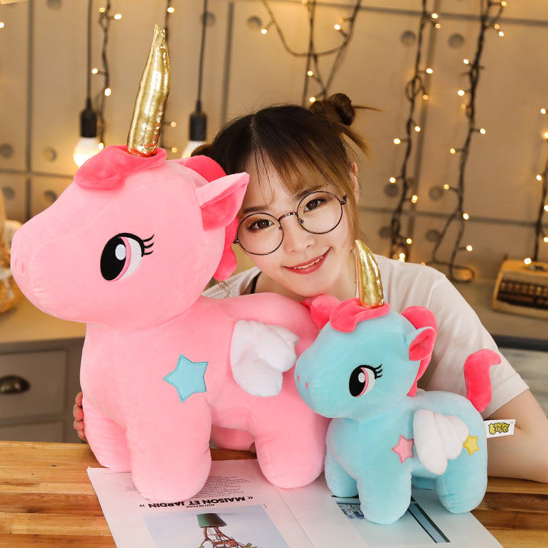 fille avec une petite et une grande peluche licorne