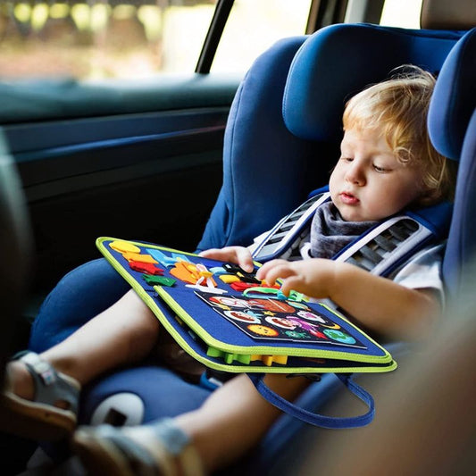 bébé joue dans planche d'activité montessori de voyage avec voiture