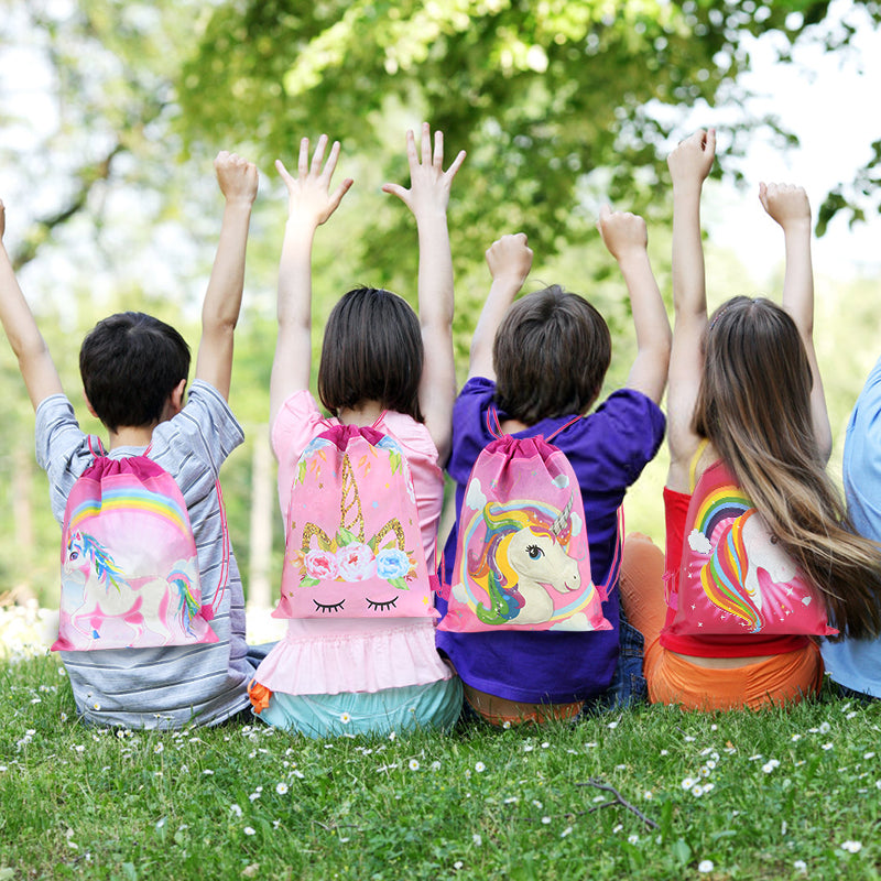 enfants avec des sac à cordon licorne les bras en l'air