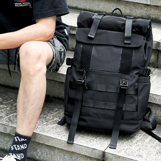 sac a dos roll top noir posé au sol