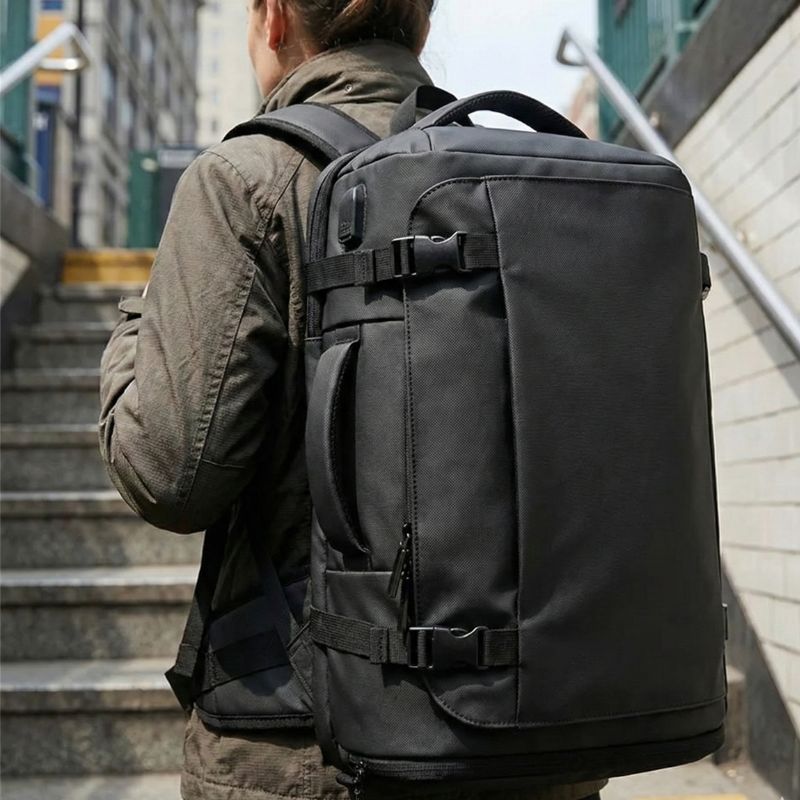 femme dans la rue avec sac a dos valise cabine au dos