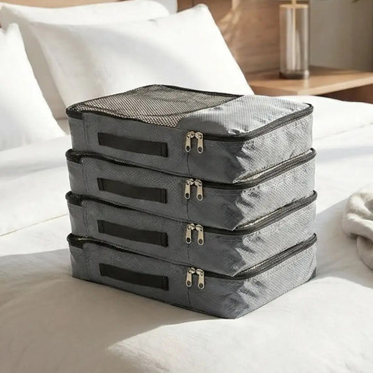 sac de compression voyage sans aspirateur 4 pièces posé sur le lit