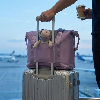 sac de voyage extensible sur une valise avec doudou a l'intérieur