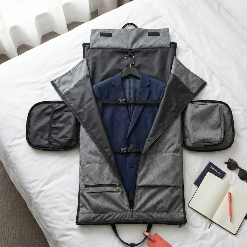 sac de voyage convertible pro posé sur un lit avec un costume non froissé à l'intérieur