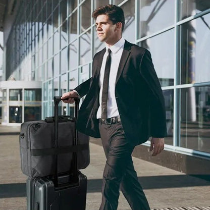 homme qui sort de l'aéorport avec valise et sac de voyage convertible sac à dos