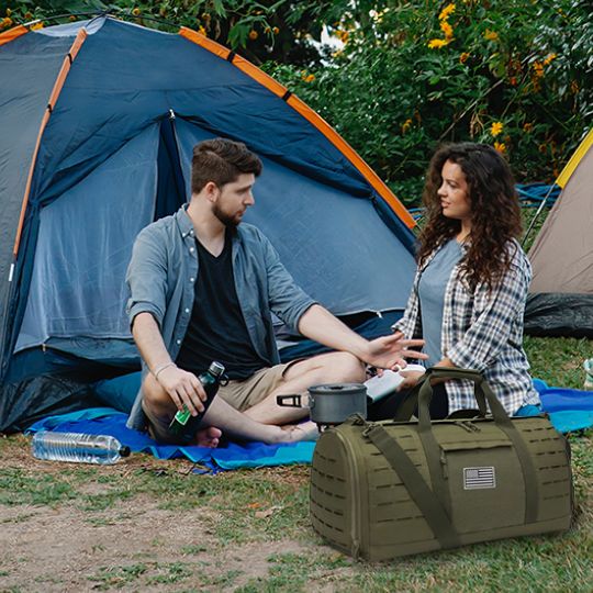 sac de voyage homme 40L militaire devant couple et tente de camping