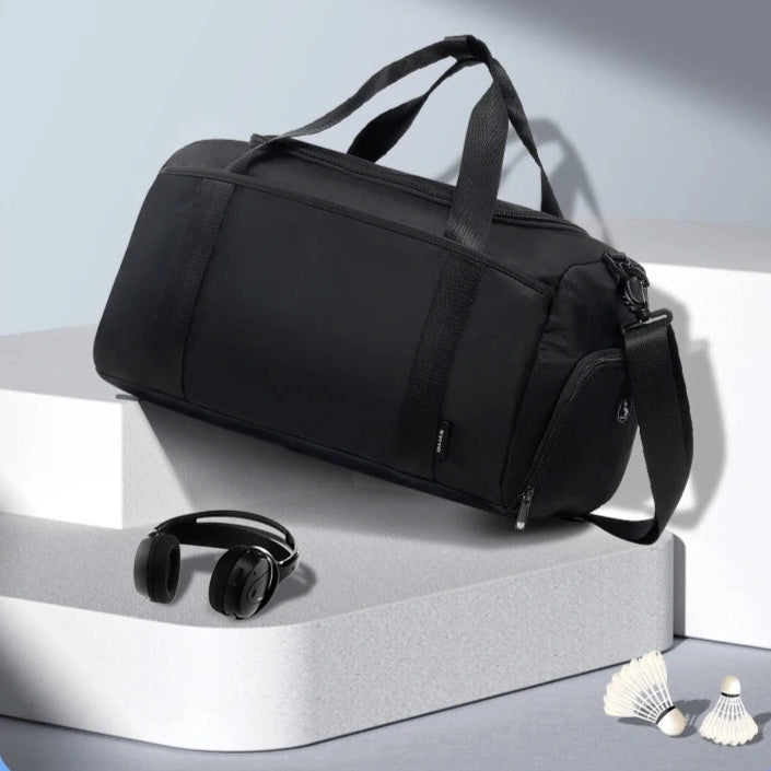 sac voyage bagage a main noir avec casque audio et volant badminton