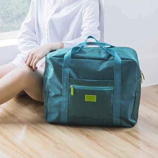 sac voyage pliable vert au sol avec femme
